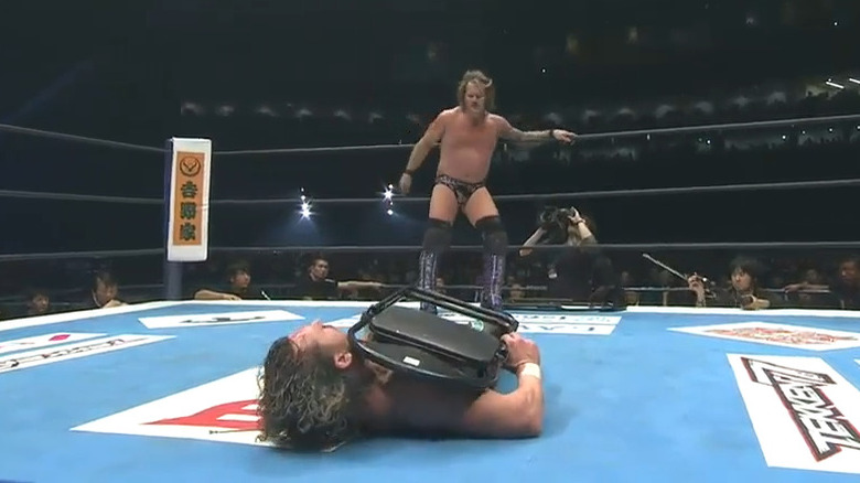 Jericho looks at Kenny Omega with chair
