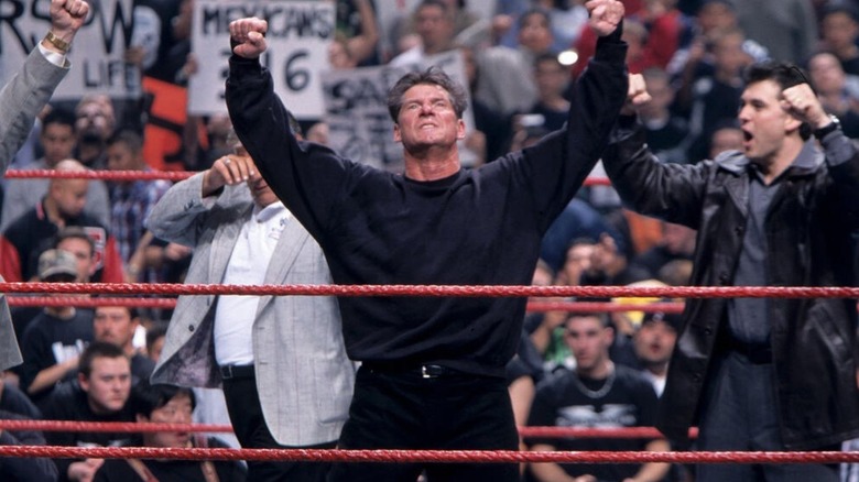 Vince McMahon raises his arms in victory in the middle of the ring after winning the 1999 Royal Rumble match.