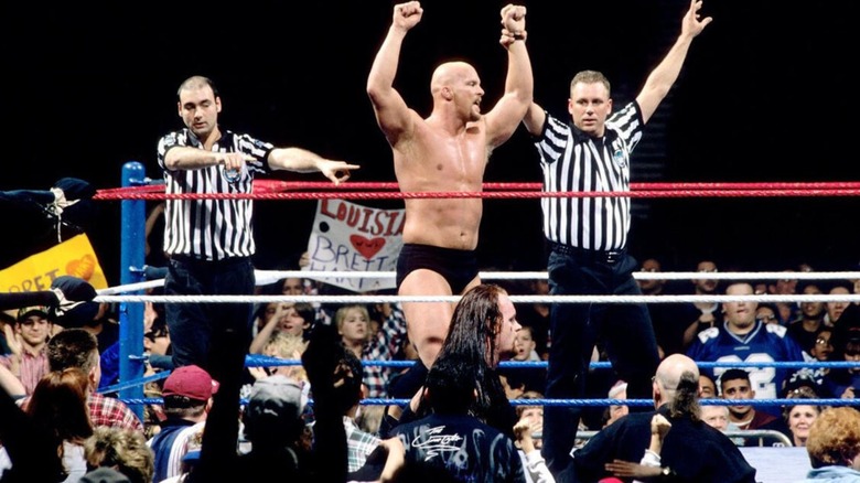 A referee raises the hand of "Stone Cold" Steve Austin in the middle of the ring at the 1997 Royal Rumble.