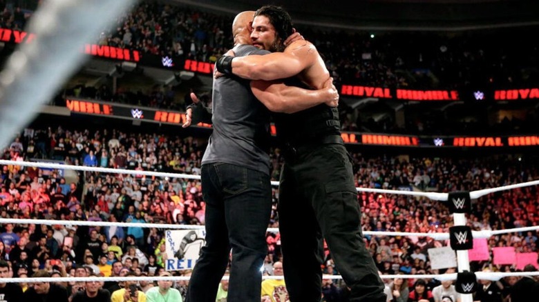 Dwayne "The Rock" Johnson and Roman Reigns embrace in the ring after Reigns' 2015 Royal Rumble victory.