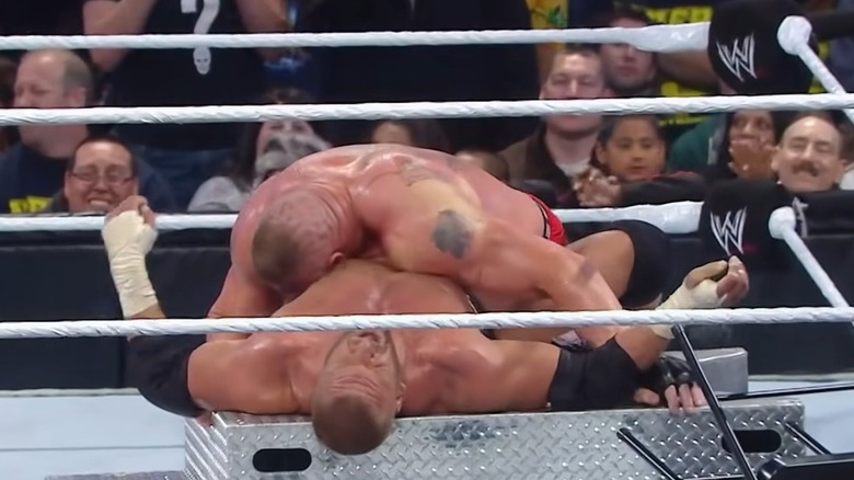 Brock Lesnar lying on top of Triple H on the stairs