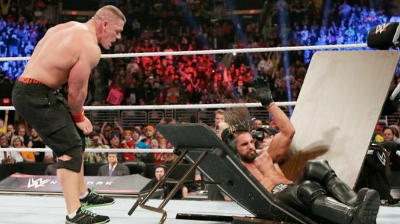 John Cena puts Seth Rollins trough a table