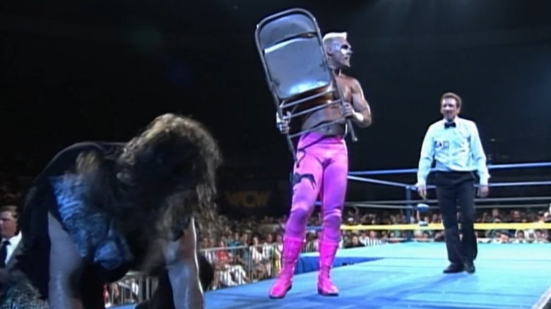 Sting holding a chair over Cactus Jack