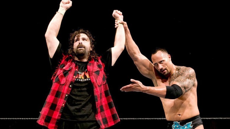 The Rock raising Mick Foley's hand