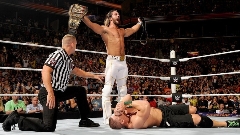 Seth Rollins standing over John Cena