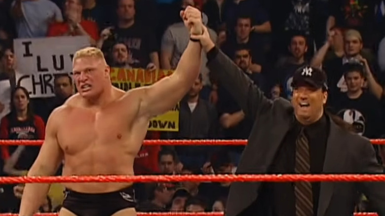 Paul Heyman holds up Brock Lesnar's arm 