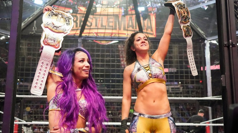 Sasha Banks and Bayley holding their WWE Women's Tag Team Championships