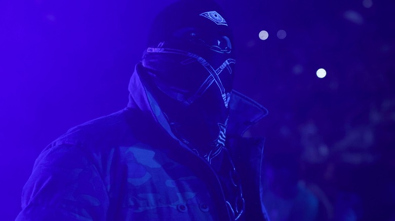 A masked Brody King makes his entrance, bathed in purple light.