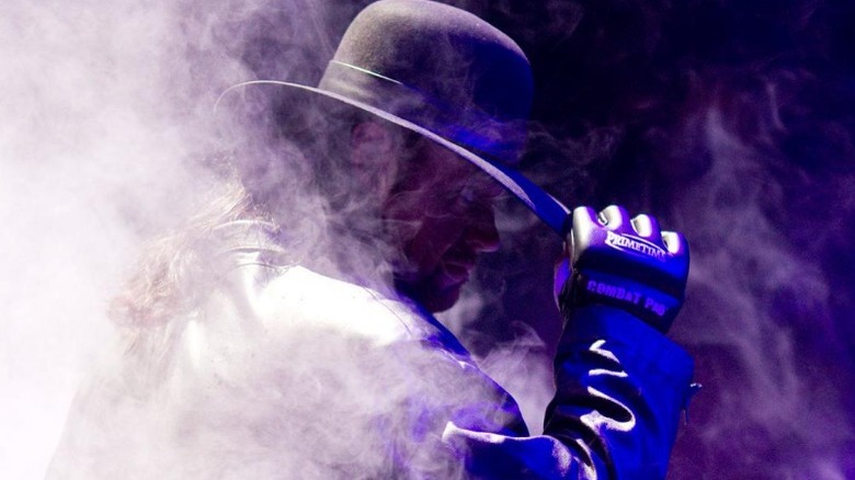 undertaker touching his hat brim