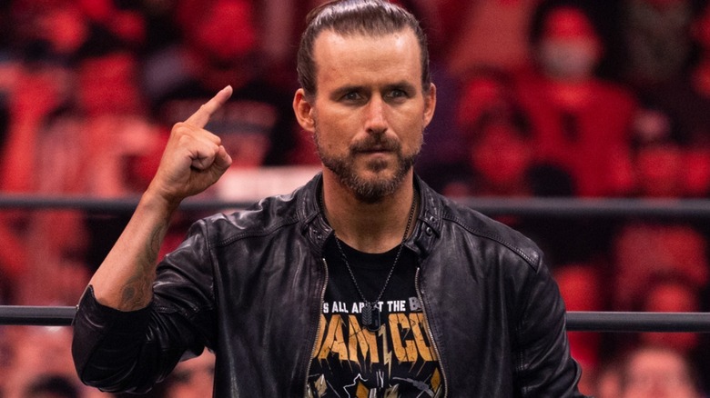 Adam Cole smiling and pointing at himself