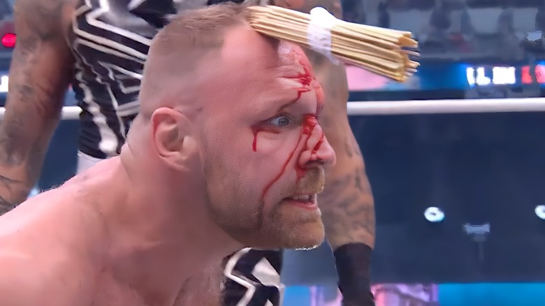 Jon Moxley with skewers stuck in his head