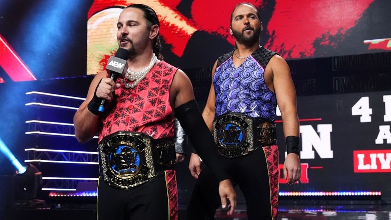 Young Bucks with microphone and title belts