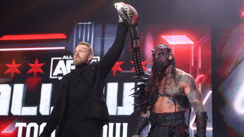 Christian Cage holding Luchasaurus's AEW TNT Championship
