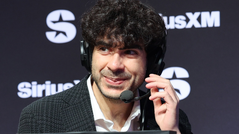 Tony Khan smiling into a headset