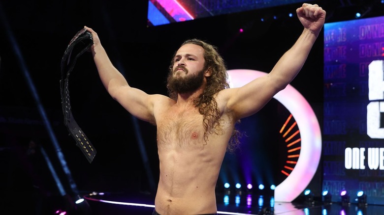 Jack Perry raises his arms and his title