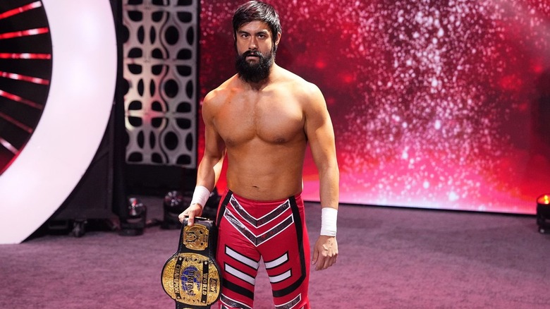 Wheeler Yuta standing with his trios title belt in hand.