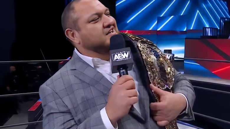 Samoa Joe with title belt and microphone