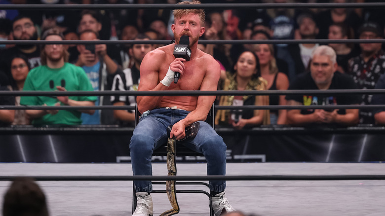 Orange Cassidy sitting in a chair with a microphone