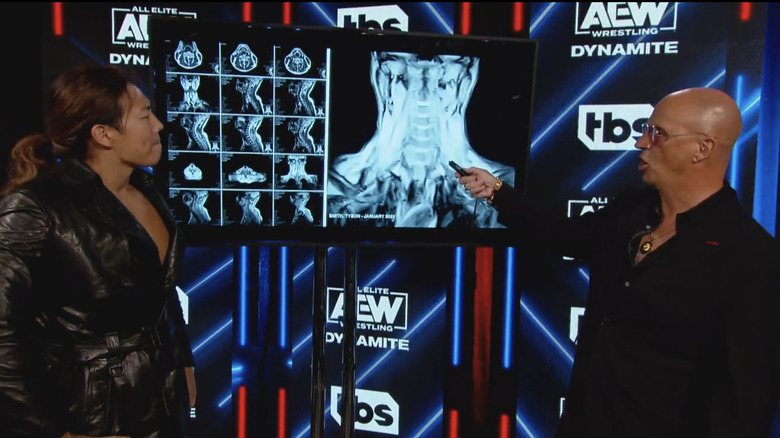 Don Callis pointing at Kenny Omega's neck x-ray