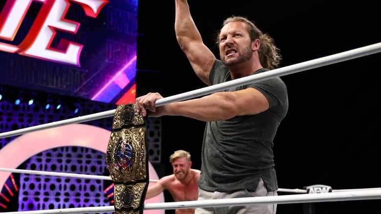 kenny omega poses next to the aew intercontinental title