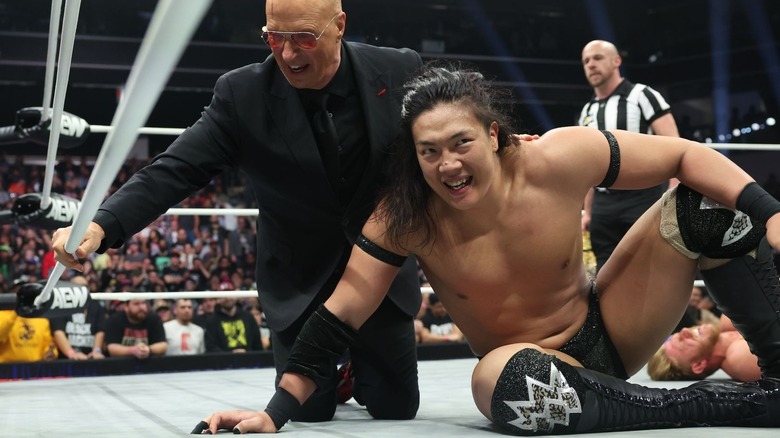 Konosuke Takeshita sitting in the ring alongside Don Callis and a in front of a fallen Orange Cassidy on "AEW Dynamite."