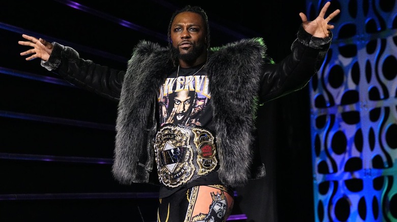 Swerve Strickland with arms wide, wearing title belt