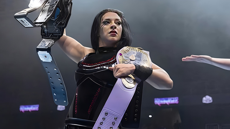 Stephanie Vaquer holding two title belts