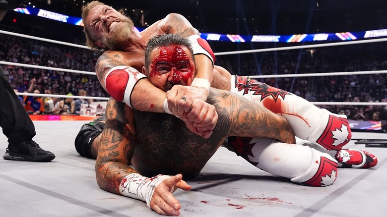 Adam Copeland with a submission hold on a bloody Brody King