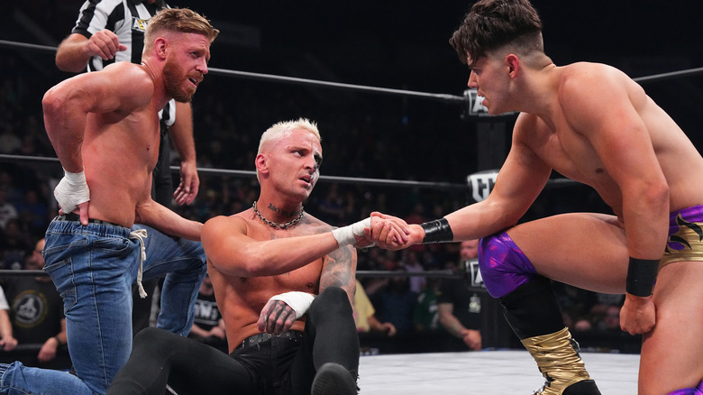 Sammy Guevara checking on Orange Cassidy and Darby Allin