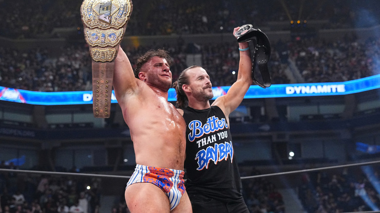 MJF and Adam Cole hold up their titles