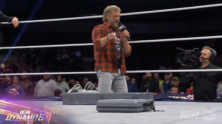 Cope speaking in the ring as he looks at Spike and the briefcase