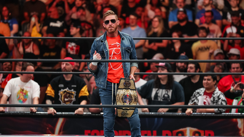 Orange Cassidy posing with his title