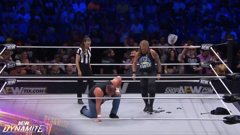 Jericho standing over Joe and the horseshoes 
