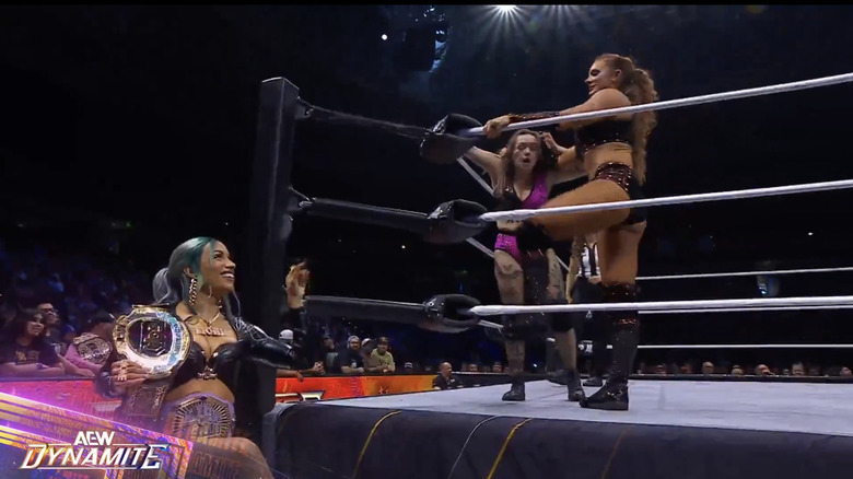 Kamille and Jade in the ring as Mone watches from ringside