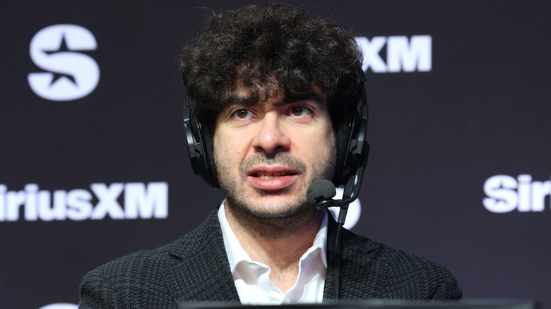 Tony Khan wearing a headset in front of a SiriusXM backdrop