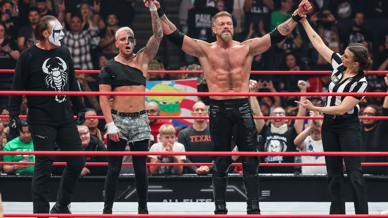 Sting, Darby Allin, and Adam Copeland with arms raised