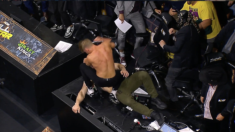 Cassidy raining down right hands on Moxley on the announce desk