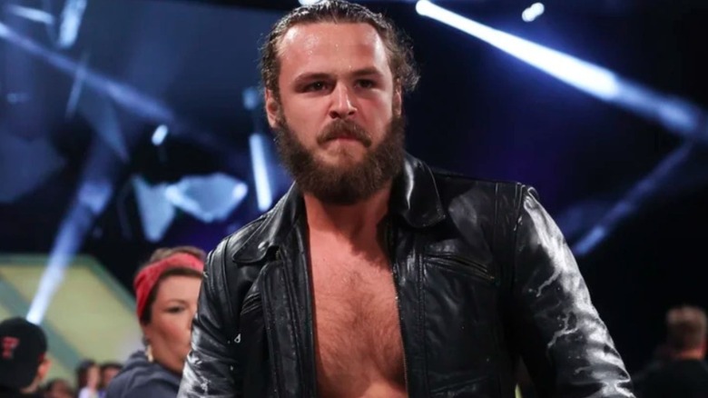 Jack Perry stands from outside of the ring, looking in, ahead of a match on AEW programming.