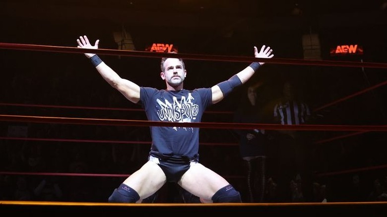 Roderick Strong kneeling with arms raised