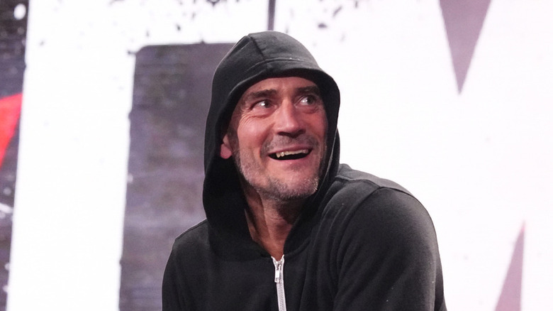 CM Punk smiling while wearing a hooded sweater