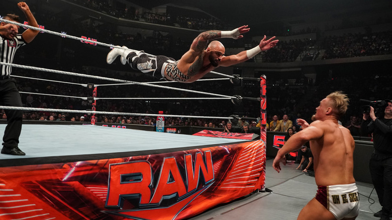 Ricochet performing a suicide dive on an oppoent