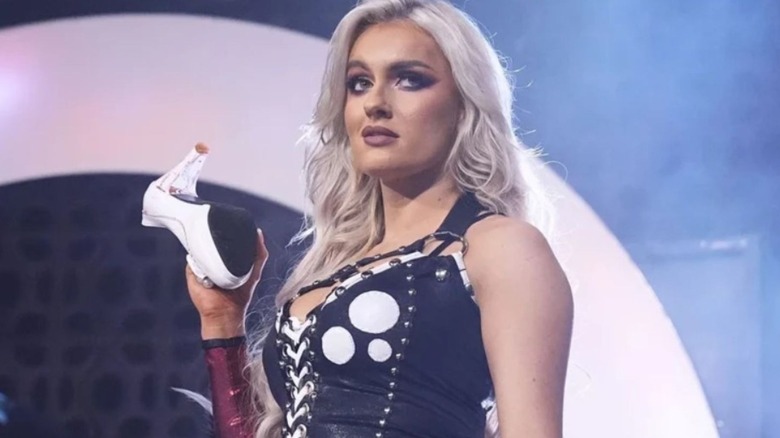 Mariah May holds up a bloody shoe she used to batter Toni Storm on the stage during an episode of AEW TV.