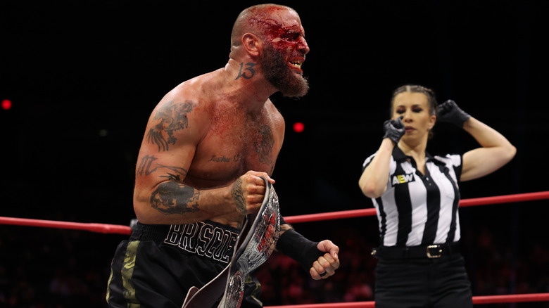 A bloody Mark Briscoe holding the ROH world title