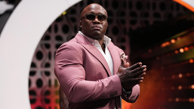 Bobby Lashley stands on the stage, wearing sunglasses, during a segment on 