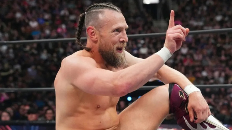 Bryan Danielson holds finger up while sitting in wrestling ring