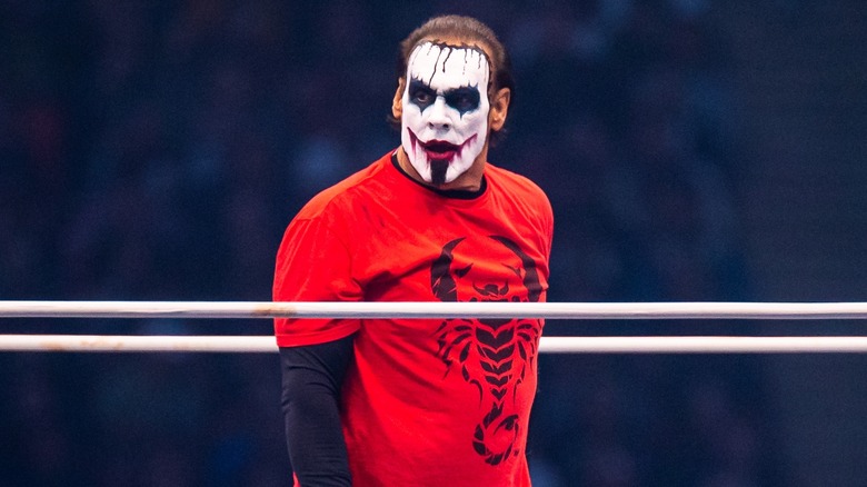 Sting standing in the ring wearing Joker makeup