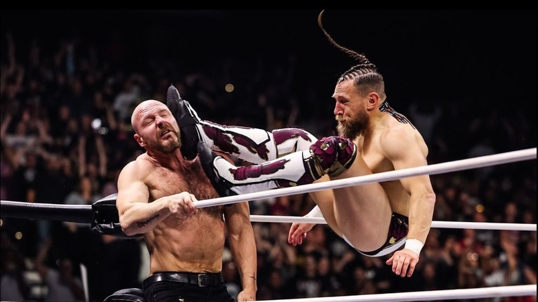 Bryan Danielson lands a missile dropkick to Jon Moxley in the corner