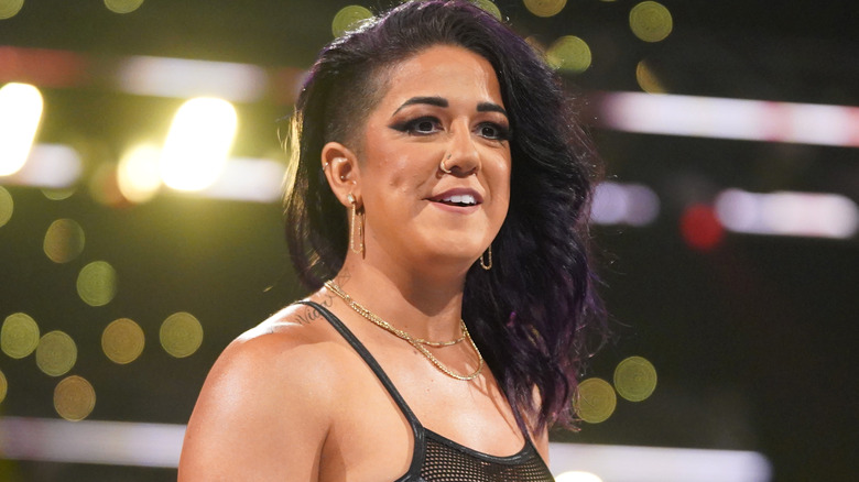 Bayley is wearing gold dangly earrings.