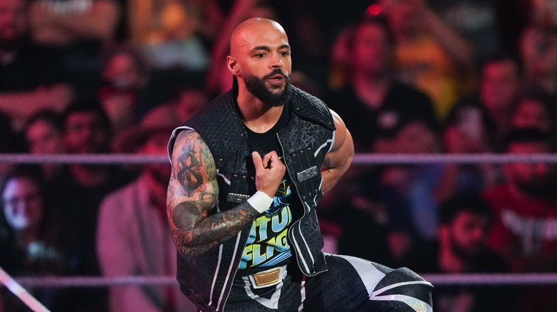 Ricochet either pointingt to himself, giving a thumbs up, or touching his chest in a weird way