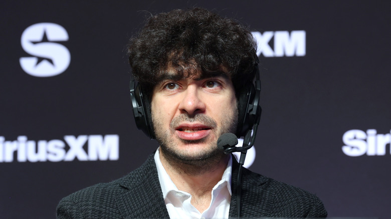 Tony Khan, headset on, images of AEW in Arena Mexico in his head